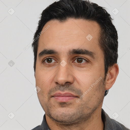 Joyful latino adult male with short  black hair and brown eyes