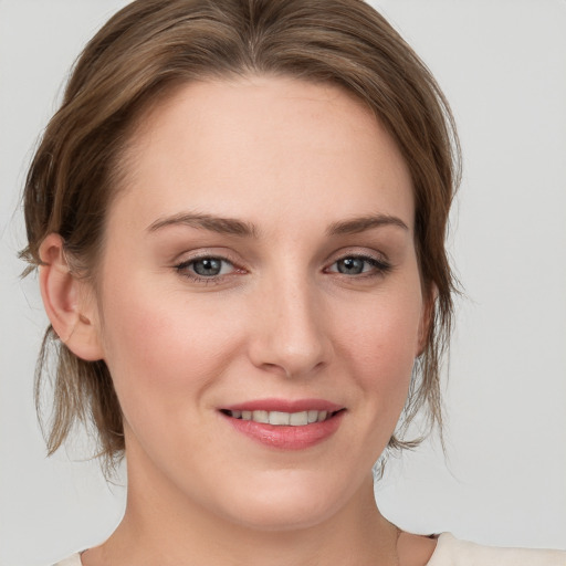 Joyful white young-adult female with medium  brown hair and grey eyes