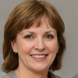 Joyful white adult female with medium  brown hair and grey eyes