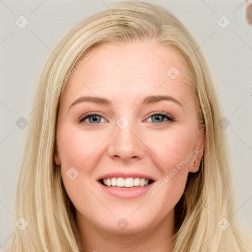 Joyful white young-adult female with long  brown hair and blue eyes