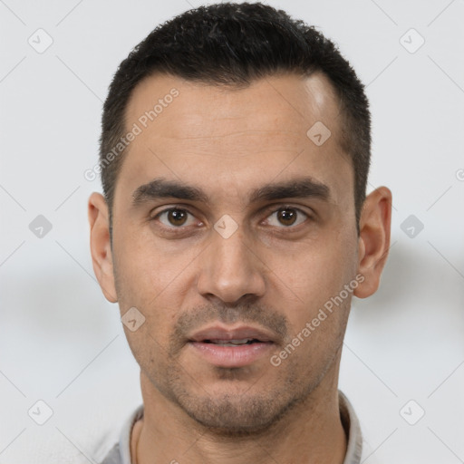 Joyful white young-adult male with short  black hair and brown eyes