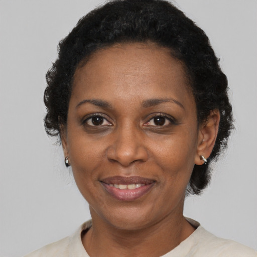 Joyful black adult female with short  black hair and brown eyes