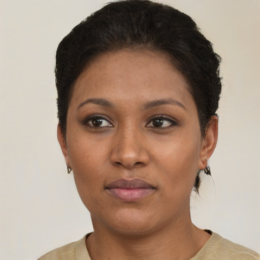 Joyful black young-adult female with short  black hair and brown eyes