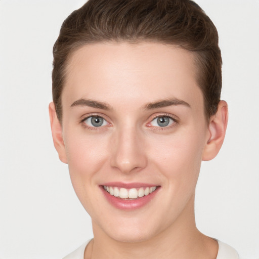 Joyful white young-adult female with short  brown hair and grey eyes