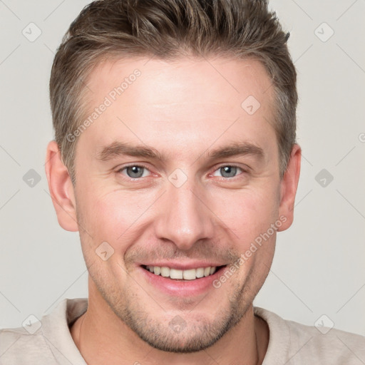 Joyful white young-adult male with short  brown hair and grey eyes