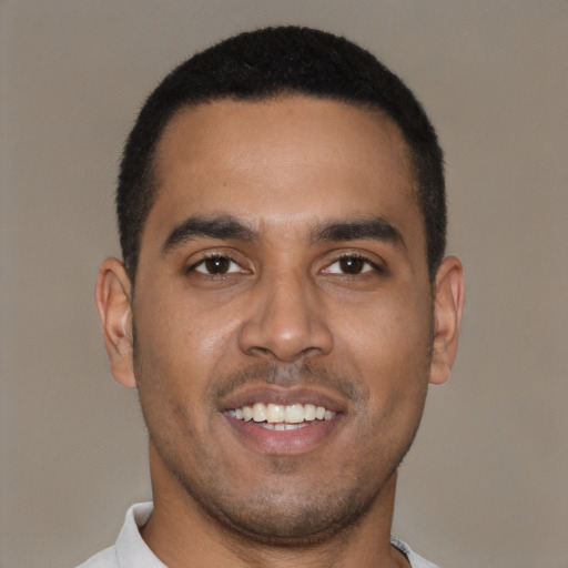 Joyful black young-adult male with short  black hair and brown eyes