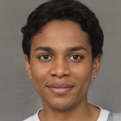 Joyful black young-adult female with short  black hair and brown eyes