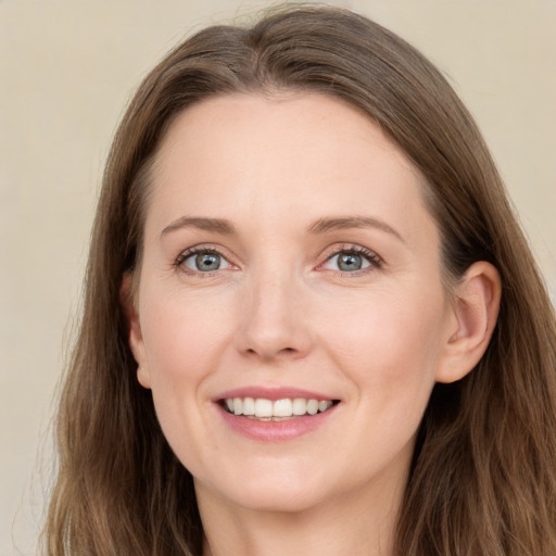 Joyful white young-adult female with long  brown hair and grey eyes