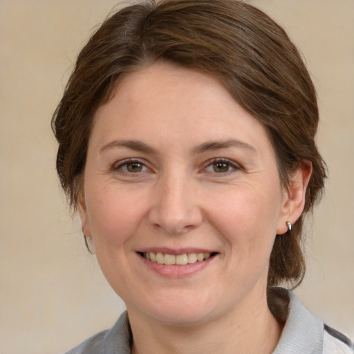 Joyful white adult female with medium  brown hair and grey eyes