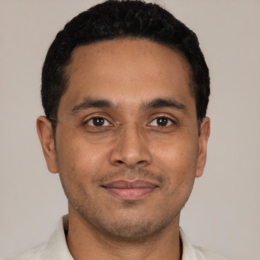 Joyful latino young-adult male with short  black hair and brown eyes