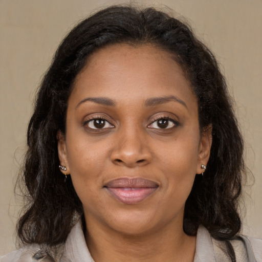 Joyful black young-adult female with long  brown hair and brown eyes