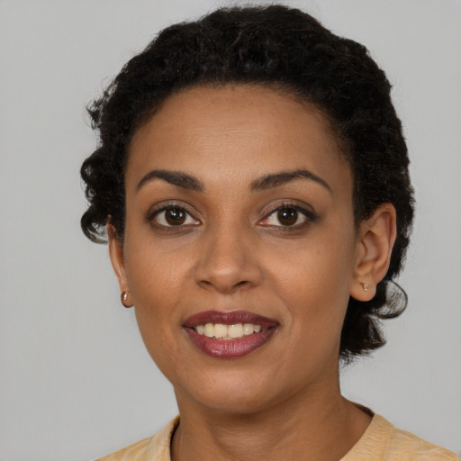Joyful black young-adult female with short  brown hair and brown eyes