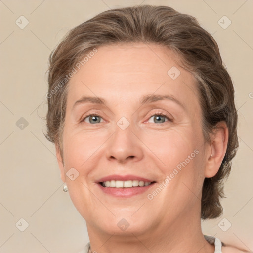 Joyful white adult female with medium  brown hair and green eyes