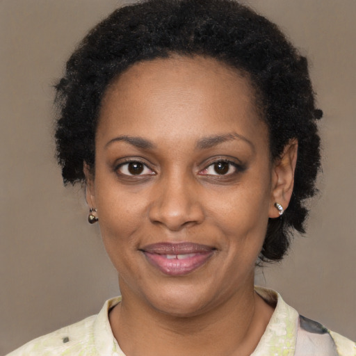 Joyful black young-adult female with short  black hair and brown eyes