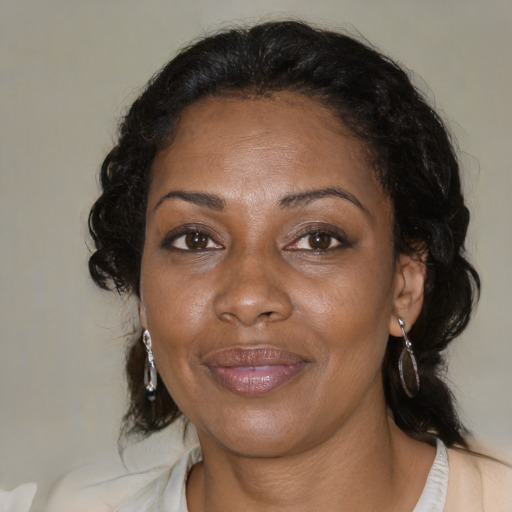 Joyful black adult female with medium  brown hair and brown eyes