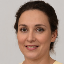 Joyful white adult female with medium  brown hair and brown eyes