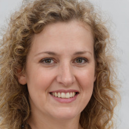 Joyful white young-adult female with long  brown hair and green eyes