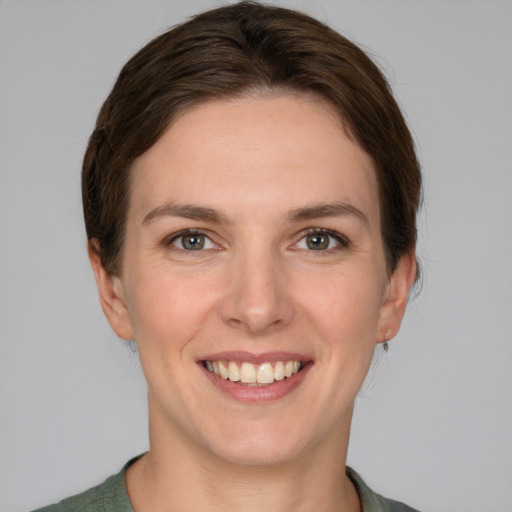 Joyful white young-adult female with short  brown hair and grey eyes