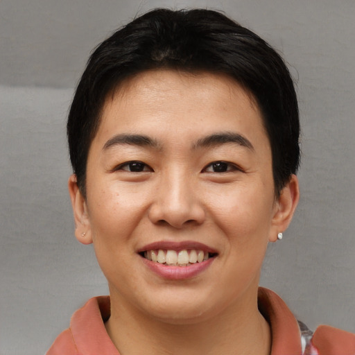 Joyful asian young-adult female with short  brown hair and brown eyes