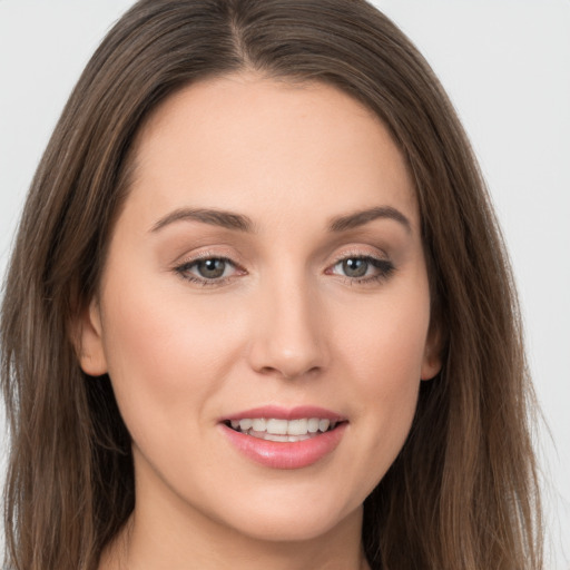 Joyful white young-adult female with long  brown hair and grey eyes