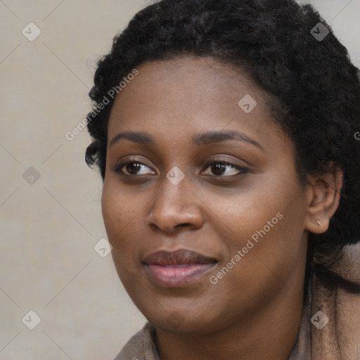 Joyful black young-adult female with long  black hair and brown eyes