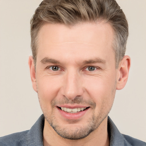 Joyful white adult male with short  brown hair and grey eyes