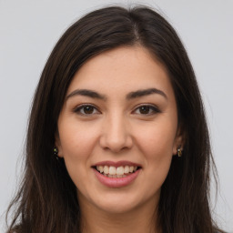 Joyful white young-adult female with long  brown hair and brown eyes