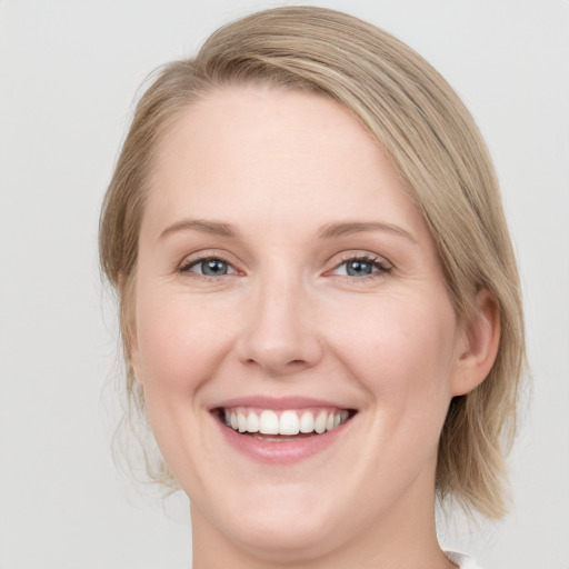 Joyful white young-adult female with medium  brown hair and blue eyes