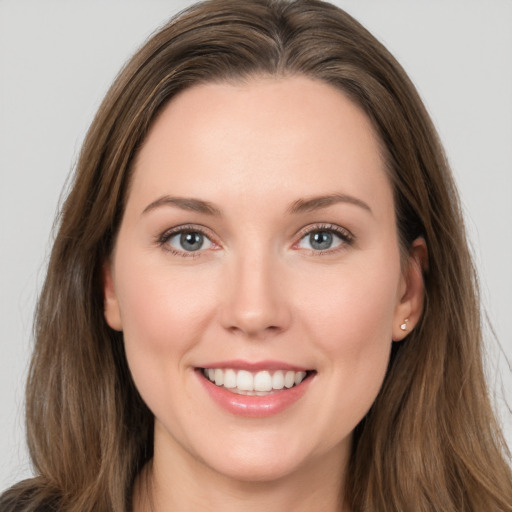 Joyful white young-adult female with long  brown hair and grey eyes