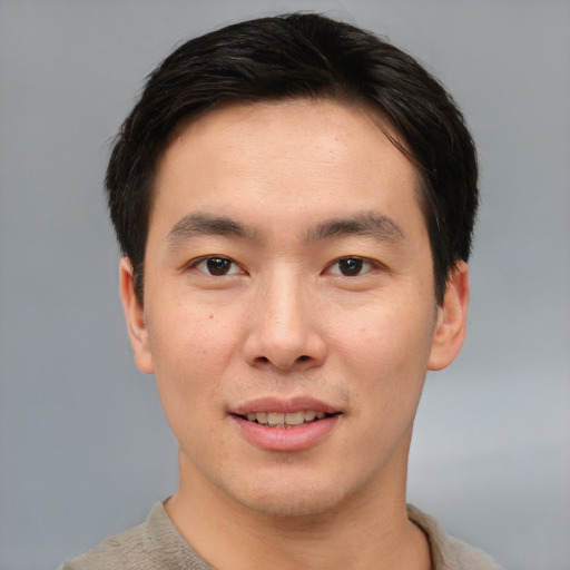 Joyful asian young-adult male with short  brown hair and brown eyes
