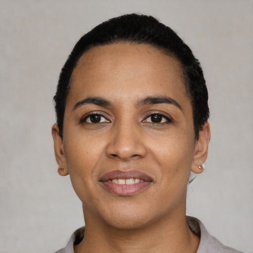 Joyful latino young-adult female with short  black hair and brown eyes