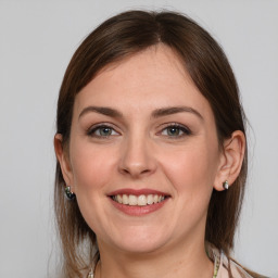 Joyful white young-adult female with medium  brown hair and grey eyes