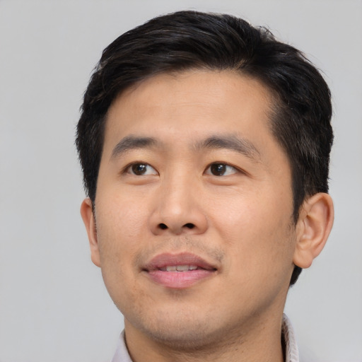 Joyful asian young-adult male with short  brown hair and brown eyes