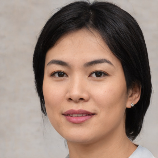 Joyful asian young-adult female with medium  black hair and brown eyes
