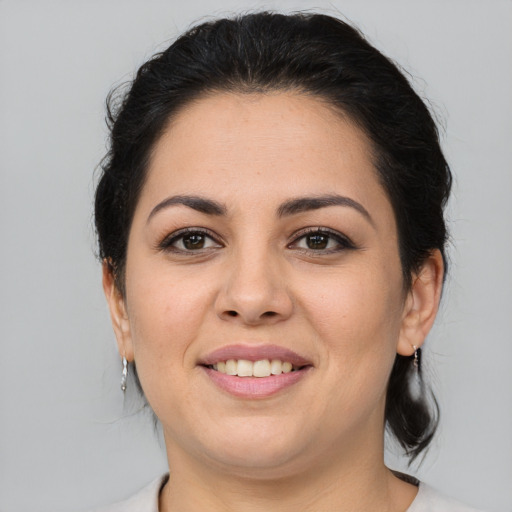Joyful latino young-adult female with medium  brown hair and brown eyes