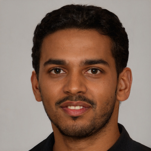 Joyful black young-adult male with short  black hair and brown eyes