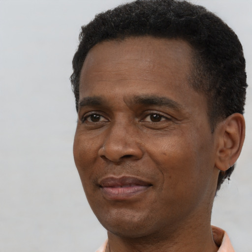 Joyful black adult male with short  black hair and brown eyes