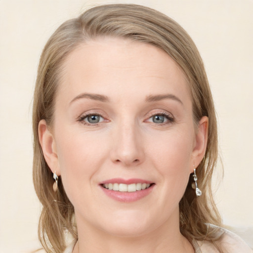 Joyful white young-adult female with medium  brown hair and blue eyes