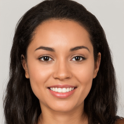 Joyful latino young-adult female with long  brown hair and brown eyes