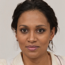 Joyful black adult female with medium  brown hair and brown eyes