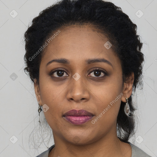 Joyful black young-adult female with long  brown hair and brown eyes