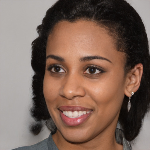 Joyful black young-adult female with medium  black hair and brown eyes