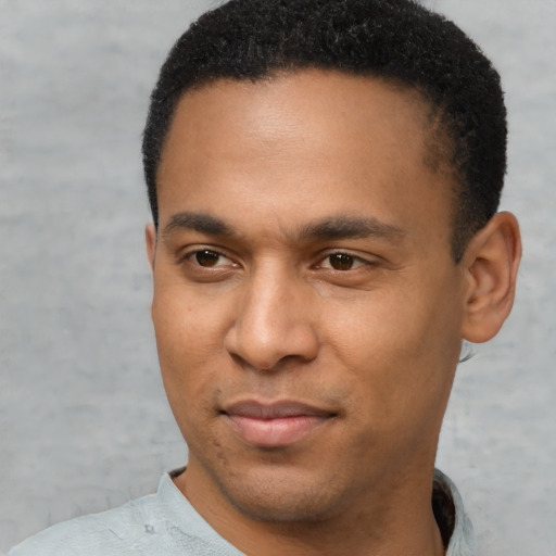 Joyful latino young-adult male with short  brown hair and brown eyes