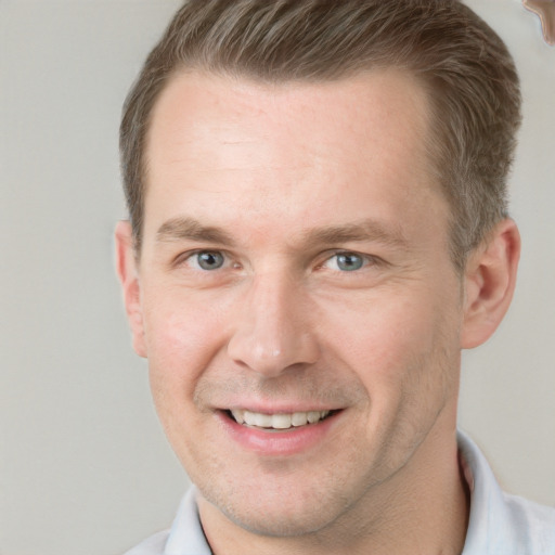 Joyful white adult male with short  brown hair and grey eyes