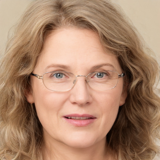 Joyful white adult female with long  brown hair and blue eyes