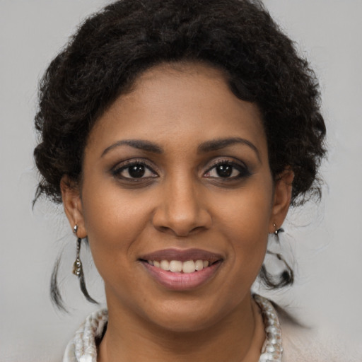 Joyful black young-adult female with medium  brown hair and brown eyes