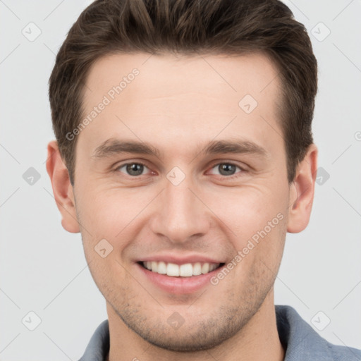 Joyful white young-adult male with short  brown hair and grey eyes