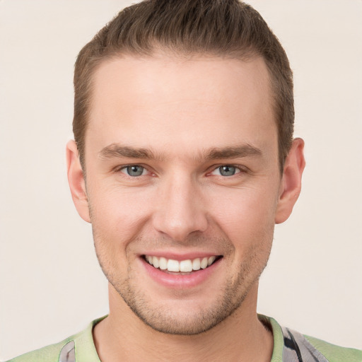 Joyful white young-adult male with short  brown hair and grey eyes