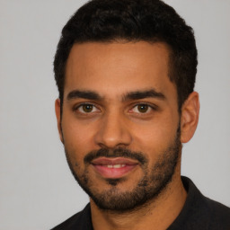 Joyful latino young-adult male with short  black hair and brown eyes