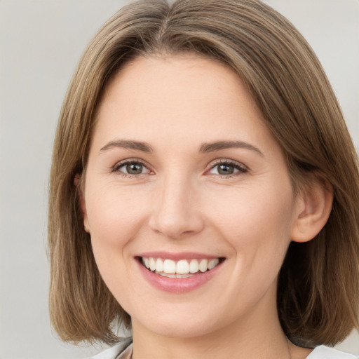 Joyful white young-adult female with medium  brown hair and green eyes